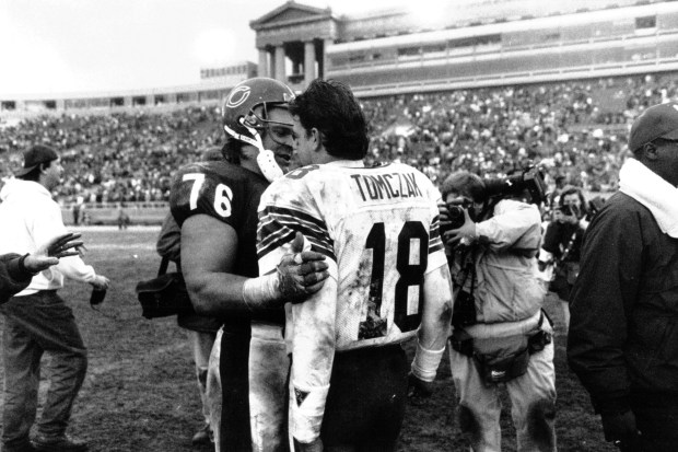 Former Bear Mike Tomczak (18) is greeted after the game by the Bears' Steve McMichael (76), who tackled Tomczak several times during the Bears vs Green Bay game at Soldier Field on Dec. 8, 1991. (Bob Fila/Chicago Tribune)