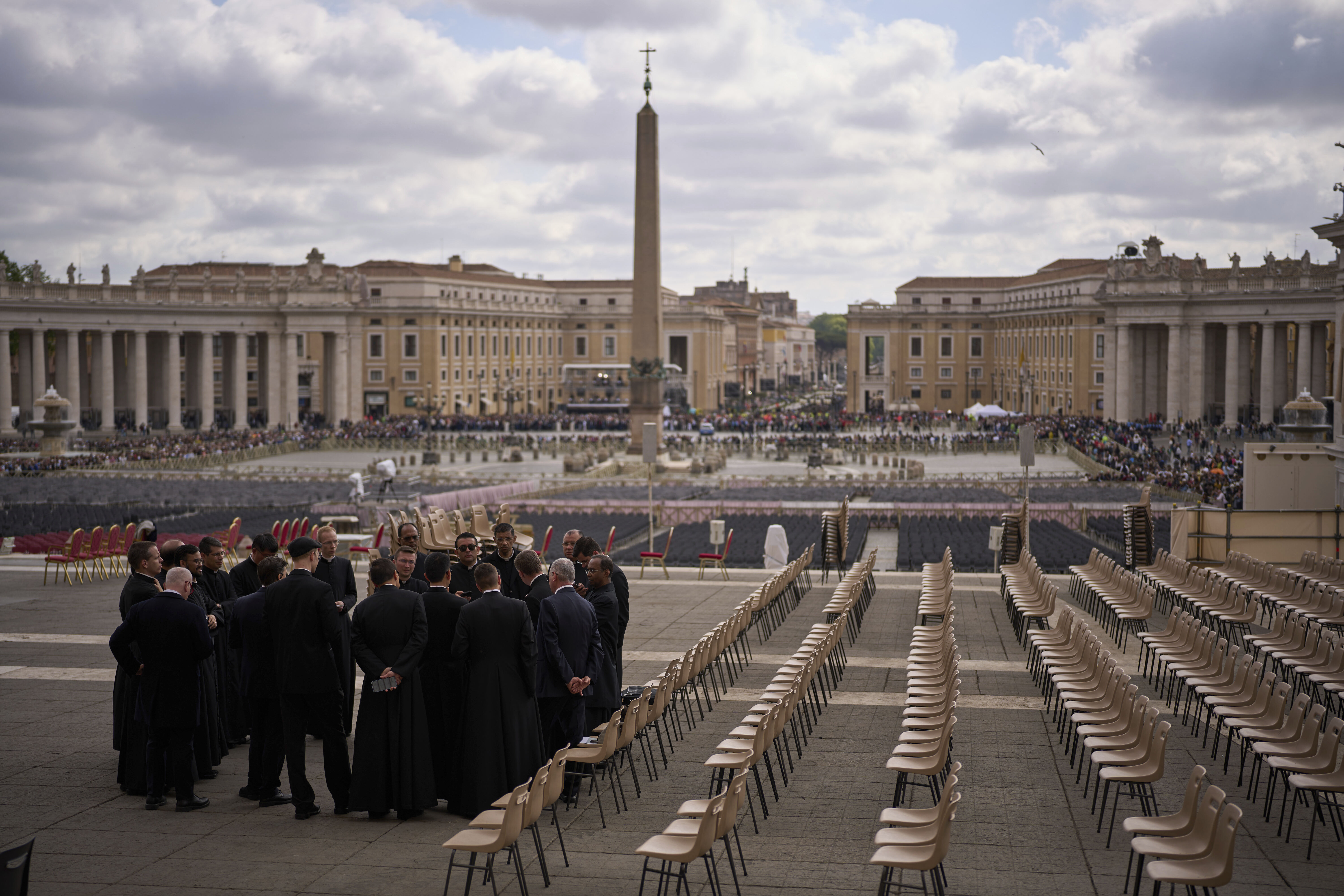 Priests and security personnel gather outside St. Peter's Basilica where Pope Francis lying in state, at the Vatican, Friday, April 25, 2025. (AP Photo/Emilio Morenatti)