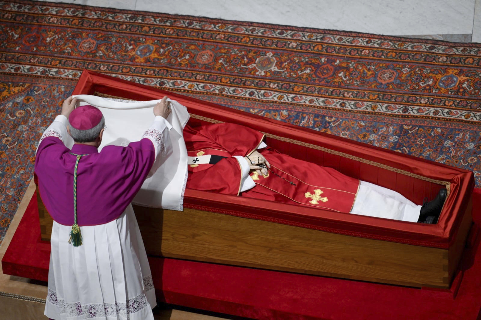 Vatican Master of Ceremonies Archbishop Diego Giovanni Ravelli covers the face of late Pope Francis with a silk cloth before closing his casket in St. Peter's Basilica at the Vatican Friday, April 25, 2025. (Vatican Media via AP)