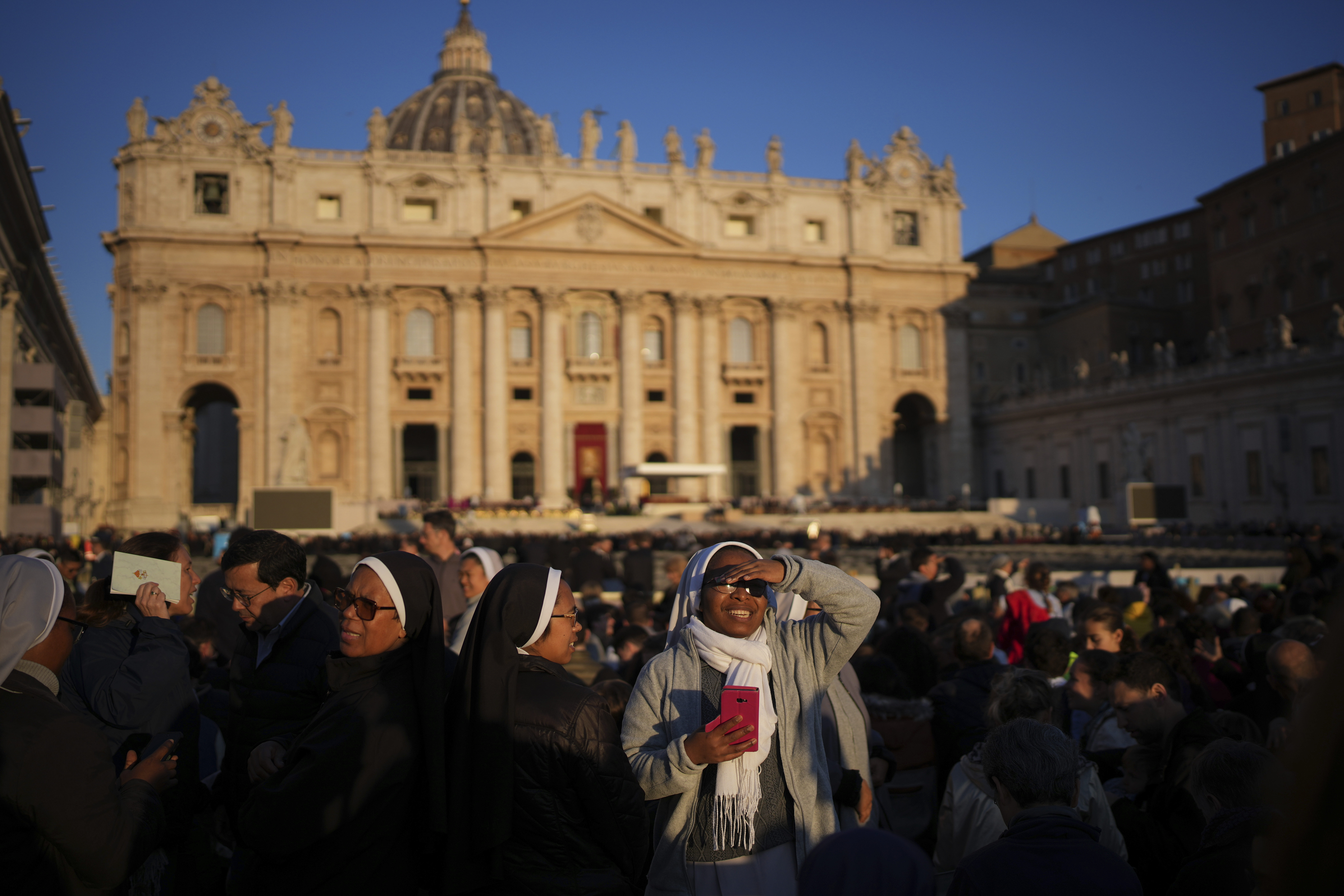 A nun smiles as she waits ahead of the funeral of Pope Francis in St. Peter's Square at the Vatican, Saturday, April 26, 2025. (AP Photo/Emilio Morenatti)