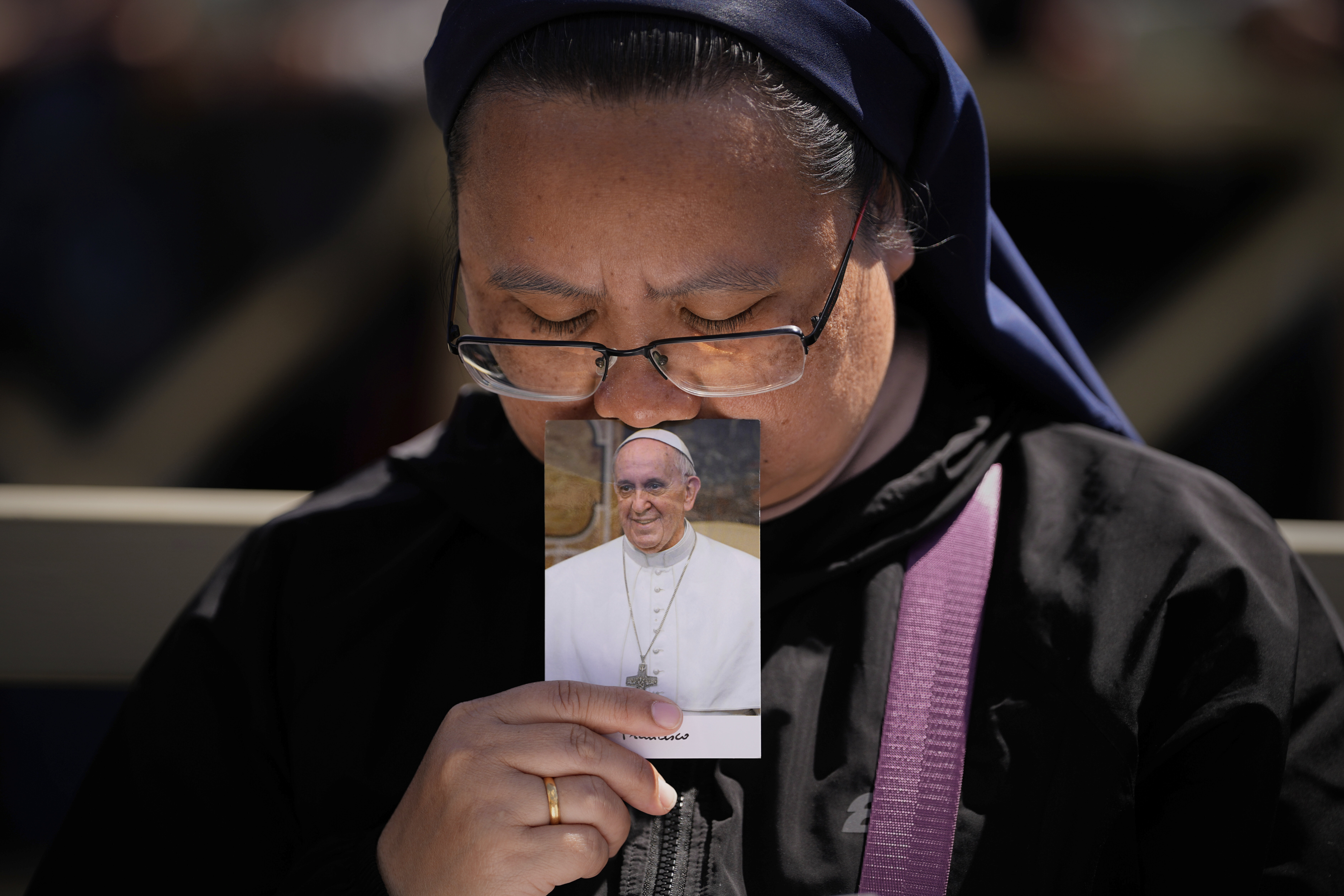 A nun holds a phot of Pope Francis while attending his funeral in St. Peter's Square at the Vatican, Saturday, April 26, 2025. (AP Photo/Andreea Alexandru)