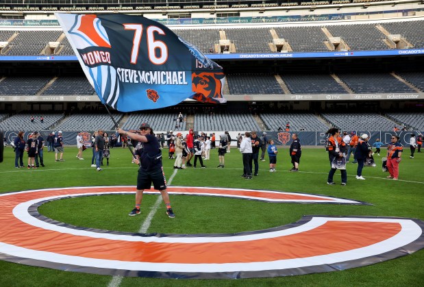 A flag honoring Bears great Steve McMichael is waved on the 50-yard line as McMichael is remembered with a moment of silence during a Bears draft party on Thursday, April 24, 2025, at Soldier Field. (Chris Sweda/Chicago Tribune)