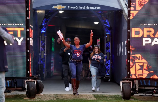 A woman runs out of the tunnel after visiting the Bears locker room as fans attend a draft party at Soldier Field on April 24, 2025. (Chris Sweda/Chicago Tribune)