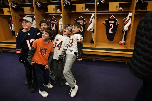 A group of children pose for a photograph while touring the Bears locker room during the Bears draft party at Soldier Field on April 24, 2025. (Chris Sweda/Chicago Tribune)