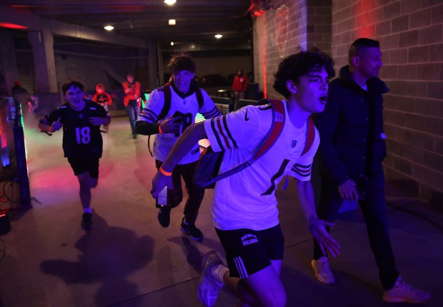 Kids react like players being announced while running through the tunnel after visiting the Bears locker room during a draft party at Soldier Field on April 24, 2025. (Chris Sweda/Chicago Tribune)