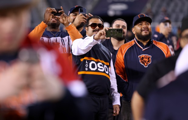 Fans prepare to document the moment at a Bears draft party at Soldier Field moments before the Bears selected Michigan tight end Colston Loveland with the No. 10 pick in the first round on April 24, 2025. (Chris Sweda/Chicago Tribune)