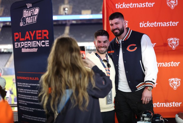 Former Bears tight end Zach Miller, right, poses for a photograph with a fan while signing autographs at the Bears draft party at Soldier Field on April 24, 2025. (Chris Sweda/Chicago Tribune)