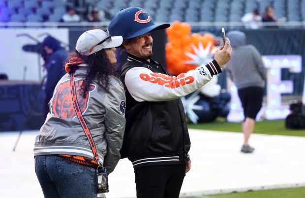 Fans take a photograph on the field while attending the Bears draft party at Soldier Field on April 24, 2025. (Chris Sweda/Chicago Tribune)