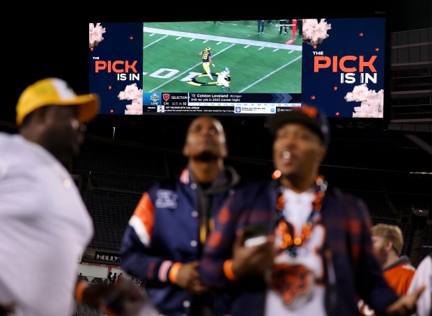 Fans attending a Bears draft party at Soldier Field watch highlights of Colston Loveland after the Michigan tight end was selected with the No. 10 pick on April 24, 2025. (Chris Sweda/Chicago Tribune)