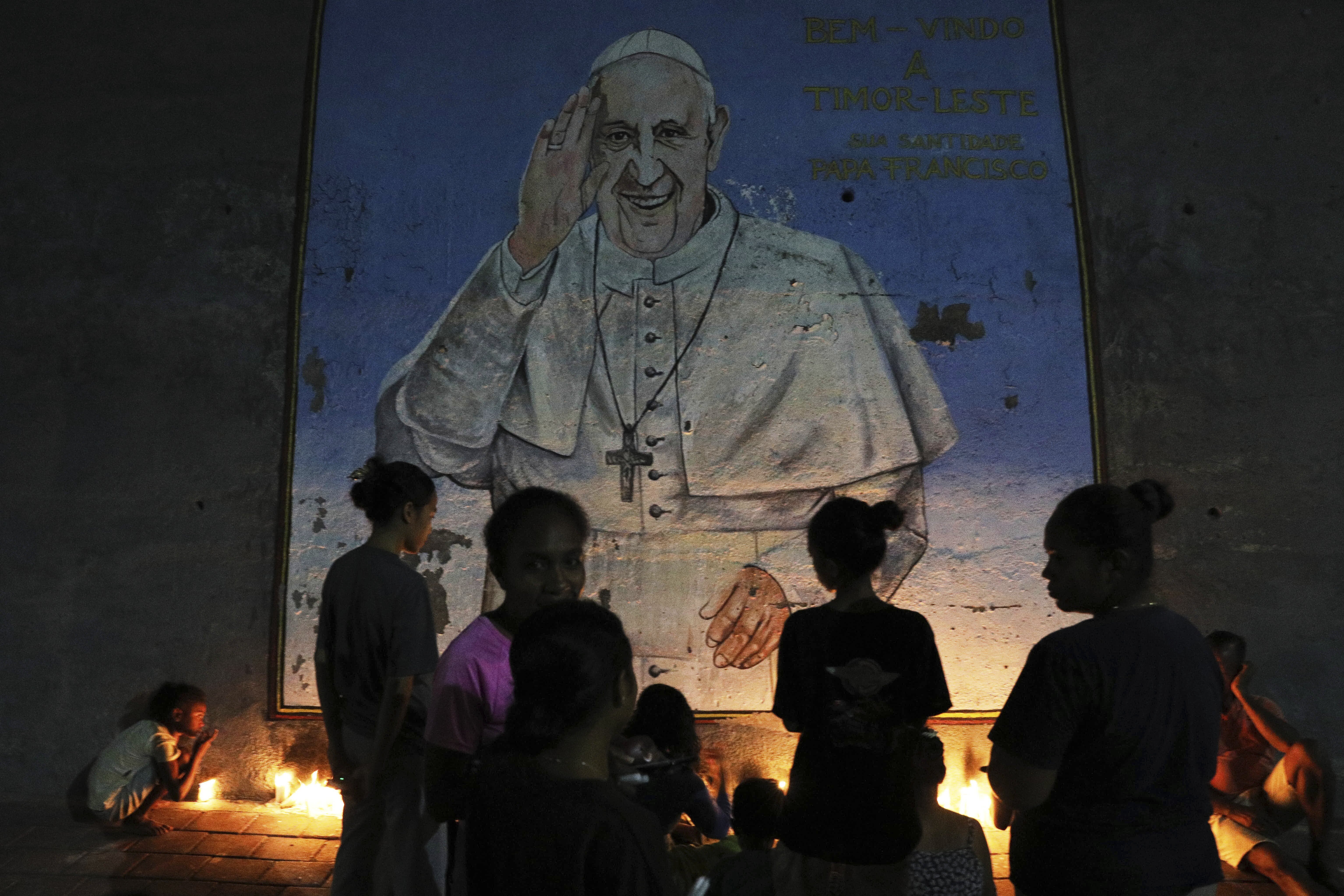 People light candles near a mural of the late Pope Francis during a vigil in Dili, East Timor, Monday, April 21, 2025. (AP)