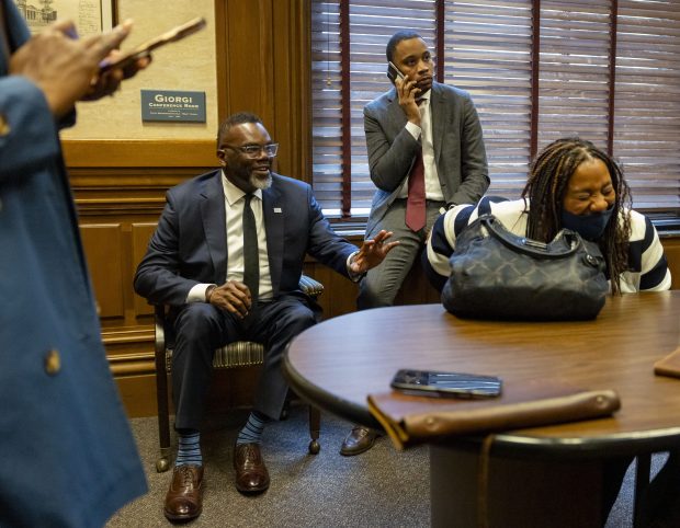 Mayor Brandon Johnson jokes with budget director Annette Guzman while senior adviser Jason Lee takes a phone call between meetings with lawmakers at the Illinois State Capitol on April 30, 2025, in Springfield. (Brian Cassella/Chicago Tribune)