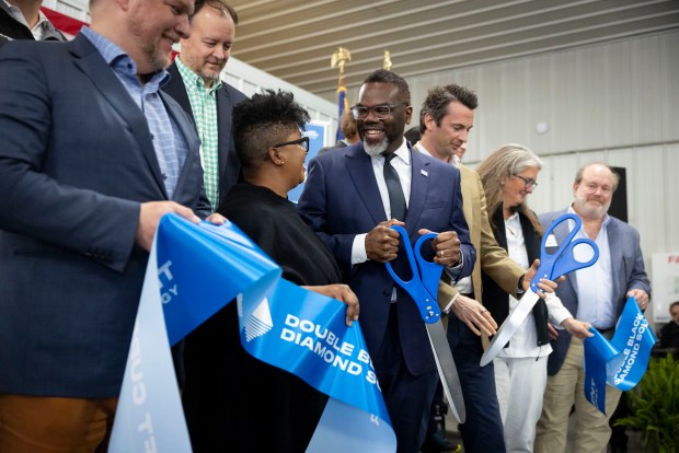 Mayor Brandon Johnson laughs with his wife, Stacie, during a ribbon cutting at the Double Black Diamond solar farm that supplies clean energy to Chicago on April 30, 2025, in Auburn, Illinois. (Brian Cassella/Chicago Tribune)