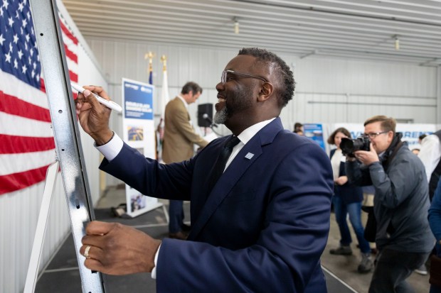 Mayor Brandon Johnson signs a panel during a ribbon cutting at the Double Black Diamond solar farm that supplies clean energy to Chicago on April 30, 2025, in Auburn, Illinois. (Brian Cassella/Chicago Tribune)