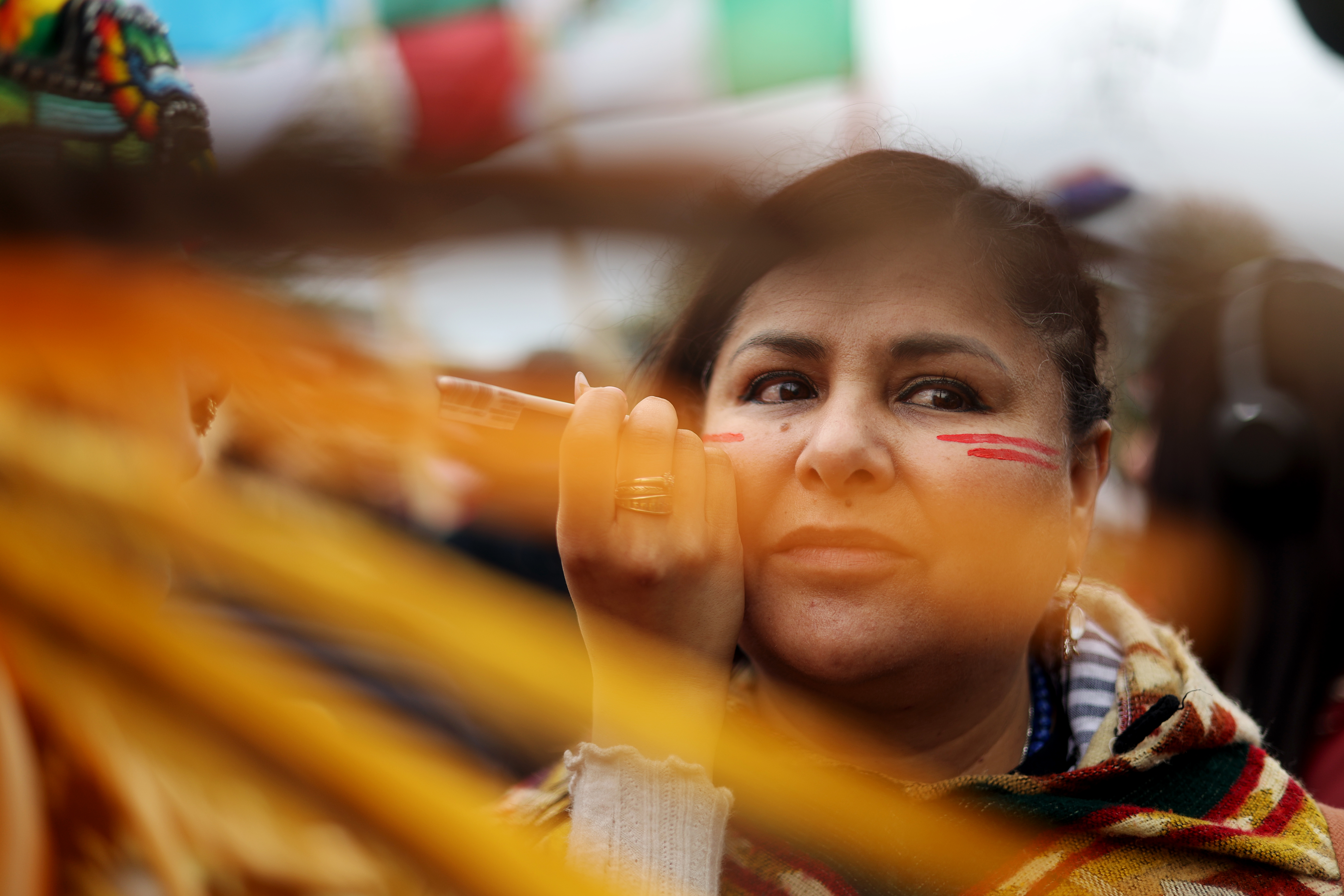 Araida Palacios gets war paint drawn on her face by Selena Sanchez, with Mexica, as hundreds gather at Union Park for the May Day march, May 1, 2025, honoring working people for International Workers' Day, before marching to Grant Park. (Audrey Richardson/Chicago Tribune)