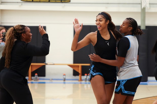Sky forward Angel Reese, center, high-fives assistant coach Rena Wakama as Reese embraces guard Ariel Atkins at the end of the first day of training camp Sunday, April 27, 2025, at Sachs Recreation Center in Deerfield. (Eileen T. Meslar/Chicago Tribune)