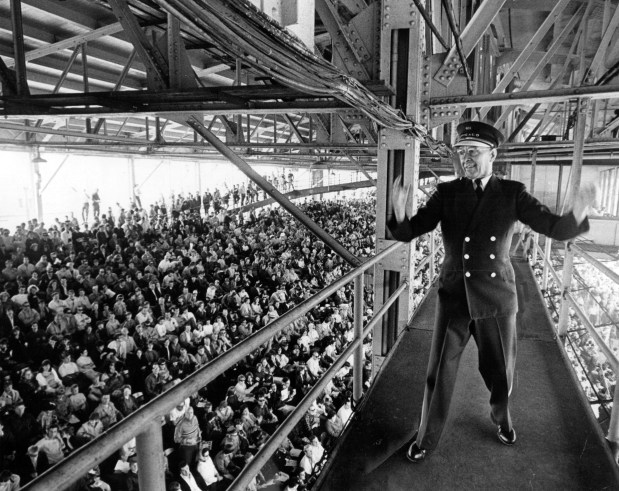 Malcolm Reeser, an Andy Frain usher who is Chicago's version of Mitch Miller, stands on the catwalk of Wrigley Field's mezzanine ramp to lead Cub fans in sing-along in May, 1969. (Steve Lasker/Chicago Today)