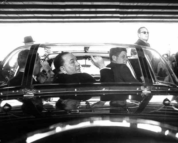 President Kennedy looks at a point of interest pointed out by Mayor Daley as they travel from airport to luncheon meeting on March 23, 1963. (Steve Lasker/Chicago American)