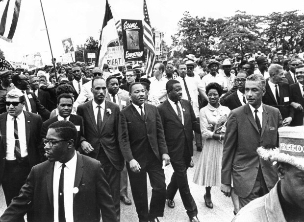 The Rev. Martin Luther King Jr., center, with Al Raby, left, covener of the Coordinating Council of Community Organizations, leads a march to protest the policies of school Supt. Benjamin Willis that began at Grant Park on July 26, 1965. (Steve Lasker/Chicago American)