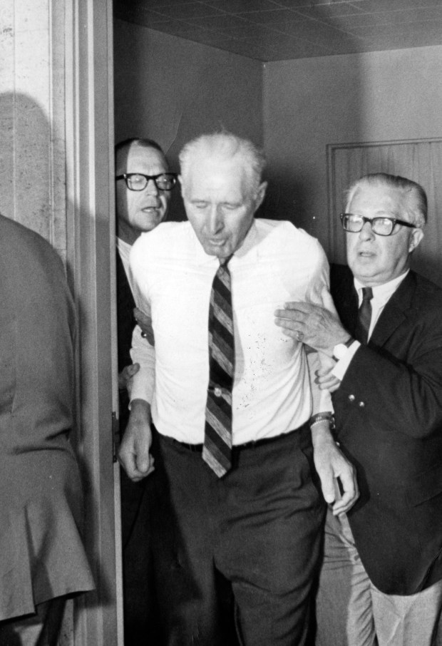John Schmale Sr., father of Nina Jo Schmale, who was murdered, is led out of the room by the coroner, Dr. Andrew Toman, right, after seeing his daughters' body at the county morgue on July 14, 1966. (Steve Lasker/Chicago Tribune)