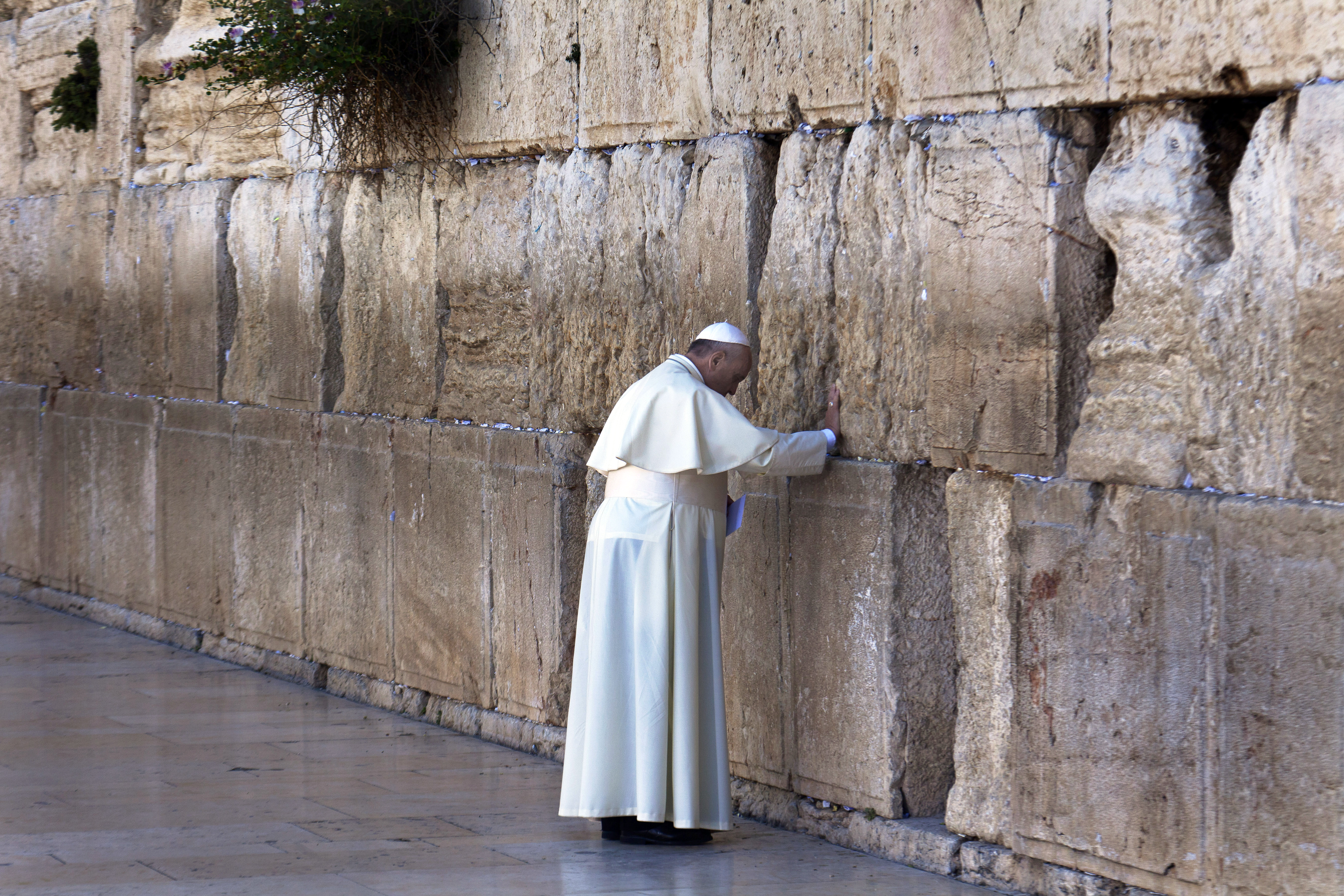 Pope Francis stands with his hand on the ancient stones of the Western Wall before placing a note between them in Jerusalem on May 26, 2014. Pope Francis, who rose from modest means in Argentina to become the first Jesuit and Latin American pontiff, died at the Vatican on Monday, April 21, 2025. He was 88. (Rina Castelnuovo/The New York Times)