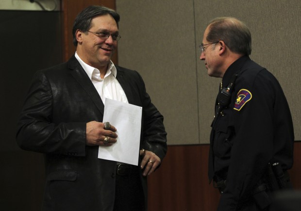 Steve McMichael chats with Police Chief Mark Turvey as McMichael attends a Romeoville village board meeting on Jan. 2, 2013. McMichael has announced that he is running for mayor. (Scott Strazzante/Chicago Tribune)